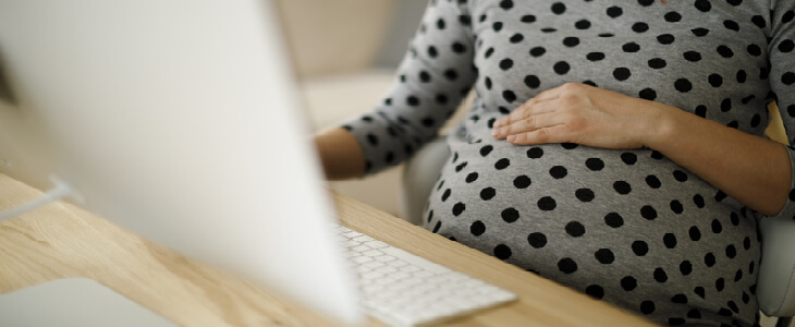 pregnant woman sitting in front of a computer