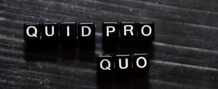 Letters on wooden blocks, spelling out Quid Pro Quo